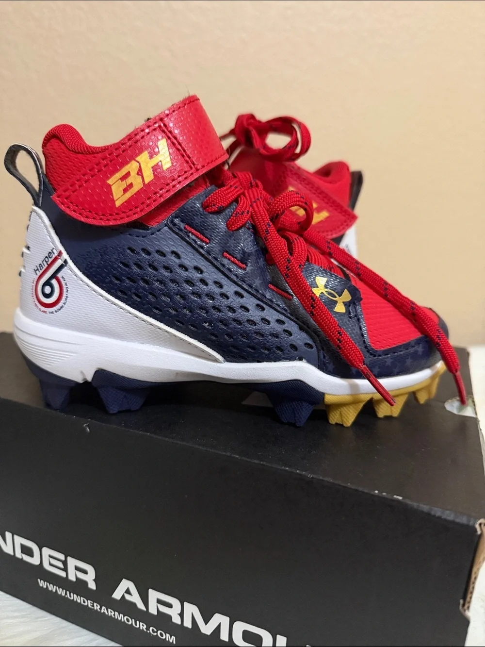 Under Armour Kids Red and Navy Football Cleats with Gold Accents